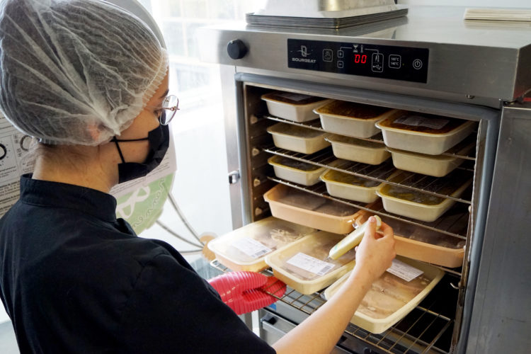 personnel en restauration collective vérifie la température des plats livrés
