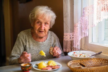 personne âgée déjeune chez elle